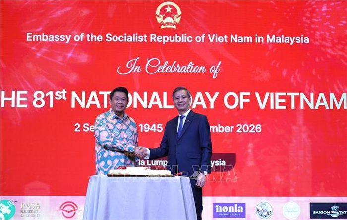 Đại sứ Đinh Ngọc Linh (phải) và Thứ trưởng Ngoại giao Malaysia Dato Lukanisman Bin Awang Sauni (trái) trong nghi thức cắt bánh chúc mừng. Ảnh: Viên Luyến/Pv TTXVN tại Malaysia