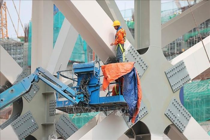 Tại công trường, các nhà thầu đang huy động hệ thống cần cẩu và tập kết các cấu kiện để chuẩn bị lắp dựng mái vòm thép có tổng trọng lượng khoảng 8.500 tấn.