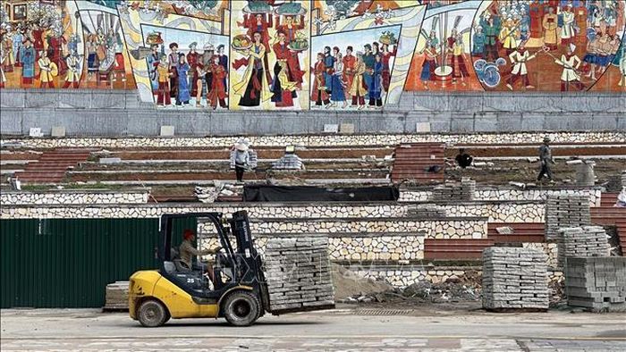 Công nhân thi công tại khu vực bức tranh gốm “Ngày hội non sông trên quê hương Đất Tổ”.