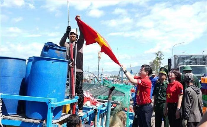 Đoàn đại biểu Hành trình “Tôi yêu Tổ quốc tôi” năm 2026 trao cờ Tổ quốc cho ngư dân treo trên tàu cá ở phường Nam Nha Trang, tỉnh Khánh Hòa.