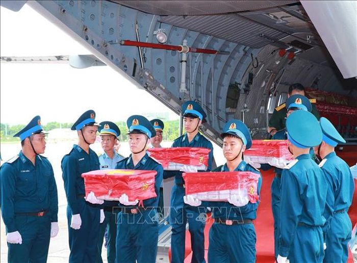 Nghi thức trang trọng chuyển mẫu hài cốt liệt sĩ từ máy bay xuống tại Sân bay Gia Lâm để làm lễ dâng hương tưởng niệm. Ảnh: Trọng Đức/TTXVN
