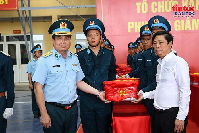 Trung tướng Vũ Hồng Sơn Tư lệnh quân chủng Quân chủng Phòng không - Không quân và Chủ tịch Hội đồng nhân dân thành phố Hồ Chí Minh Võ Văn Minh thực hiện nghi thức bàn giao mẫu sinh phẩm hài cốt liệt sĩ.