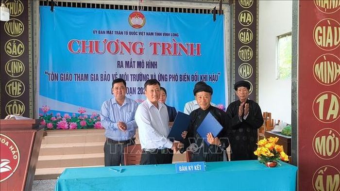 Ký cam kết giữa cở sở tôn giáo và MTTQ Việt Nam xã Phú Phụng về thực hiện mô hình cơ sở tôn giáo xanh- sạch - đẹp. Ảnh: Huỳnh Phúc Hậu/TTXVN