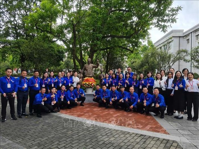 Các bạn thanh niên Việt Nam chụp ảnh bên bức tượng Bác Hồ tại trường Đại học Quảng Tây.
