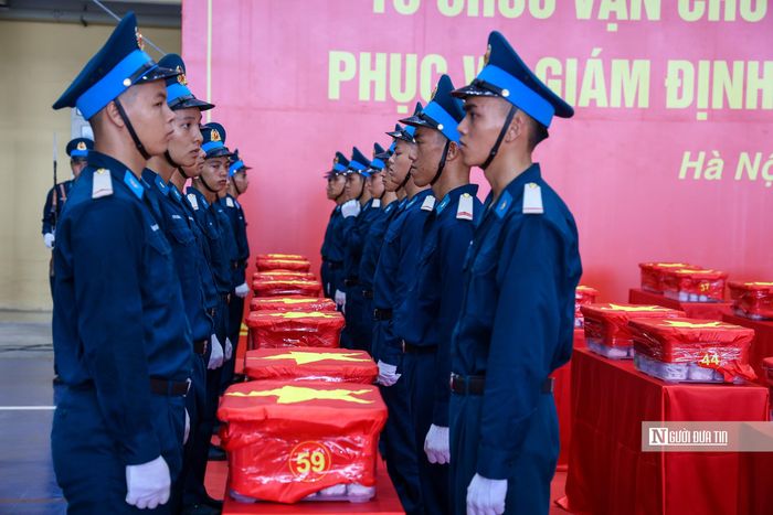 Cán bộ, chiến sĩ Quân chủng Phòng không - Không quân trang nghiêm thực hiện di chuyển các thùng chứa mẫu sinh phẩm hài cốt liệt sĩ xuống máy bay.