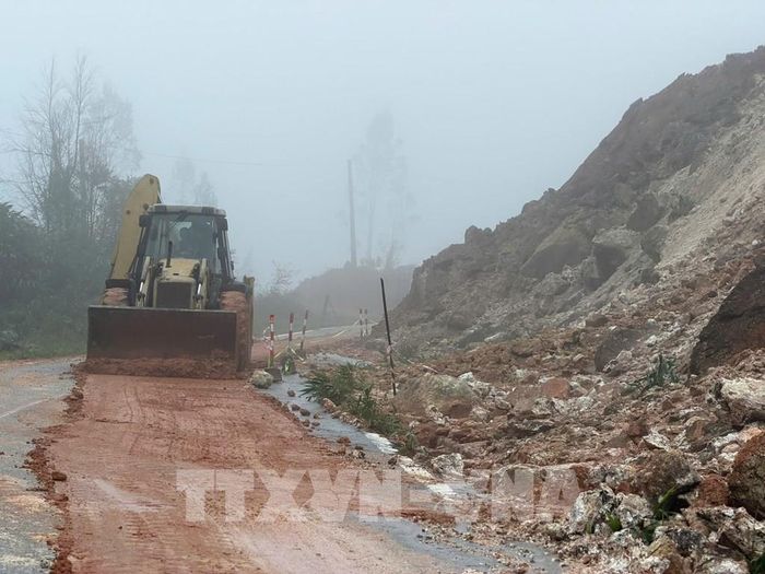Lực lượng chức năng khẩn trương xử lý các điểm sạt lở trong điều kiện thời tiết có mưa, sương mù. Ảnh: Cao Nguyên - TTXVN