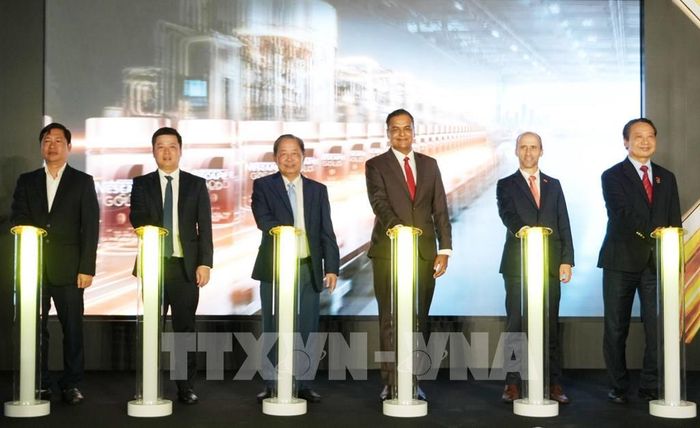 Các đại biểu thực hiện nghi thức vận hành dây chuyền đóng gói cà phê hòa tan trong hũ thủy tinh (Jar Line) tại Nhà máy Nestlé Trị An, thành phố Đồng Nai. Ảnh: Công Phong - TTXVN
