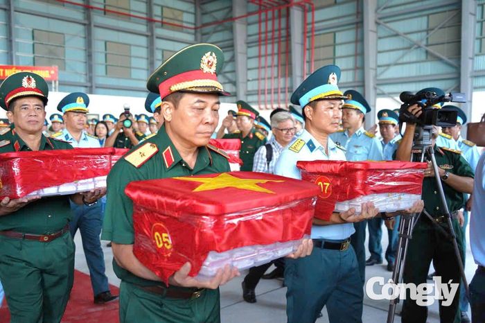 Hình ảnh đưa mẫu hài cốt liệt sĩ lên máy bay.