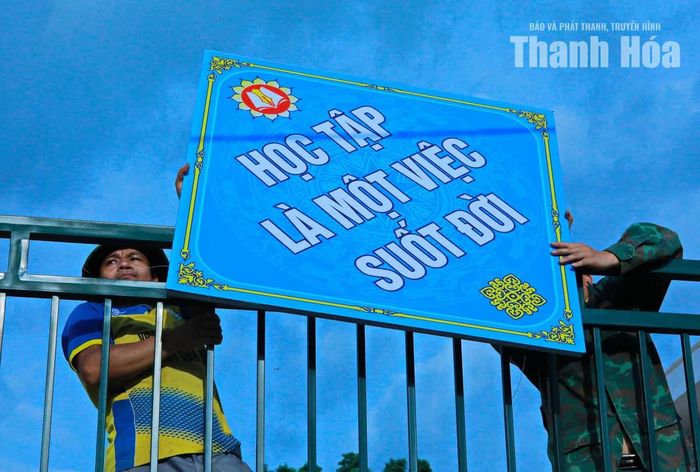 Công nhân lắp đặt các biển trang trí chờ đón ngày khai giảng.