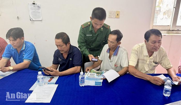 Chiến sĩ Bộ đội Biên phòng hướng dẫn người dân quét mã QR “Hòm thư điện tử ẩn danh” để tiếp nhận thông tin tố giác tội phạm. Ảnh: VĂN BÌNH