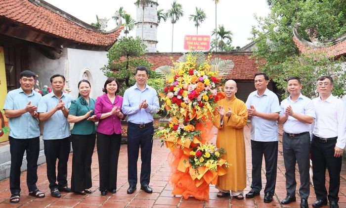 Đồng chí Trần Huy Phương (thứ 5 từ trái qua) và các đại biểu tặng hoa chúc mừng Thượng tọa Thích Thanh Sơn cùng các tăng, ni, phật tử nhân lễ Vu Lan.