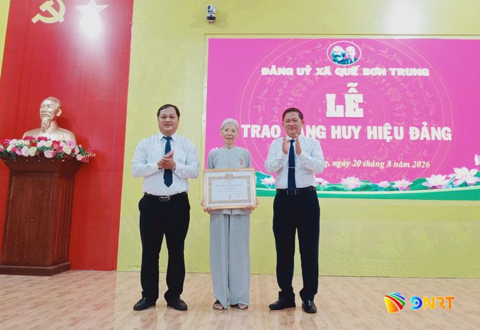Lãnh đạo xã Quế Sơn Trung trao Huy hiệu 60 năm tuổi Đảng cho đảng viên Nguyễn Thị Loan (Chi bộ thôn Trung Sơn). Ảnh: DUY THÁI