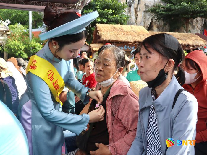 Cài bông hồng hiếu hạnh (cho người còn mẹ) cho người dân dự lễ. Ảnh: QUỐC TUẤN
