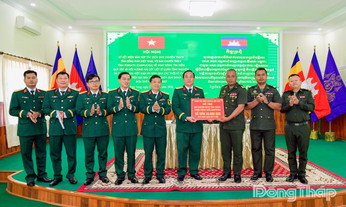 Đại tá Nguyễn Văn Hoa Chính ủy Bộ Chỉ huy Quân sự tỉnh Đồng Tháp thừa ủy quyền của Ban Chuyên trách Chính phủ Việt Nam trao kinh phí hỗ trợ Ban Chuyên trách tỉnh Pursat.