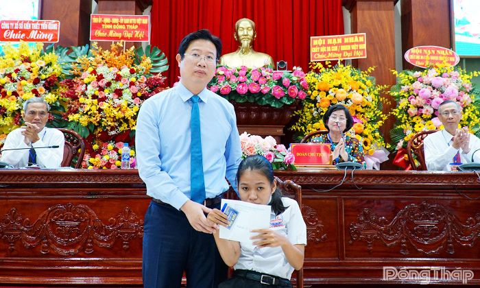 Đồng chí Huỳnh Minh Tuấn trao quà cho em Mai Thị Yến Nhi thuộc đối tượng khuyết tật do chất độc da cam/dioxin gây ra.