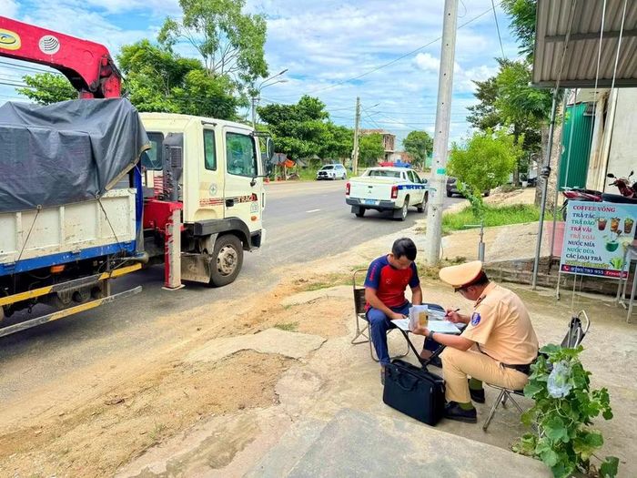 Cán bộ Trạm Cảnh sát giao thông Tuy Phước lập biên bản xử phạt tài xế sử dụng thẻ nhận dạng lái xe của người khác để đăng nhập thiết bị giám sát hành trình. Ảnh: ĐVCC
