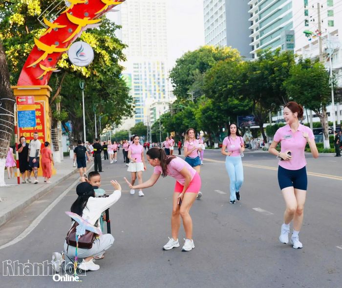 Một thí sinh dừng lại giao lưu với người hâm mộ bên đường chạy.