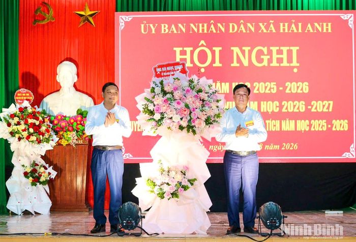 Đồng chí Bùi Ngọc Quang, Tỉnh ủy viên, Phó Giám đốc Báo và phát thanh, truyền hình Ninh Bình tặng hoa chúc mừng ngành Giáo dục xã Hải Anh. Ảnh: Khánh Dũng