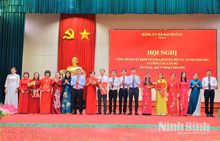 Đồng chí Trịnh Như Lâm, Tỉnh ủy viên, Bí thư Đảng uỷ, Chủ tịch HĐND xã Đại Hoàng và lãnh đạo xã Đại Hoàng trao Quyết định thành lập và tặng hoa chúc mừng các Đảng bộ trường học mới sau sắp xếp. Ảnh: Thuỷ Lam