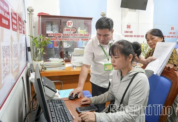 Cán bộ Trung tâm Phục vụ hành chính công xã Yên Thủy hướng dẫn người dân nộp hồ sơ thủ tục hành chính qua Cổng dịch vụ công quốc gia.