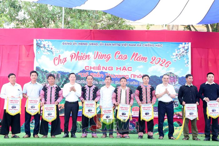 Ban tổ chức trao cờ lưu niệm cho các bản tham gia phiên chợ.