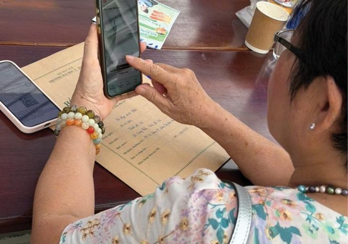Nhiều người già thành thạo chuyển khoản qua điện thoại. Ảnh: Châu Lê