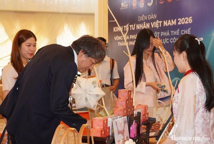  Du khách nước ngoài tìm hiểu sản phẩm của doanh nghiệp Huế. 