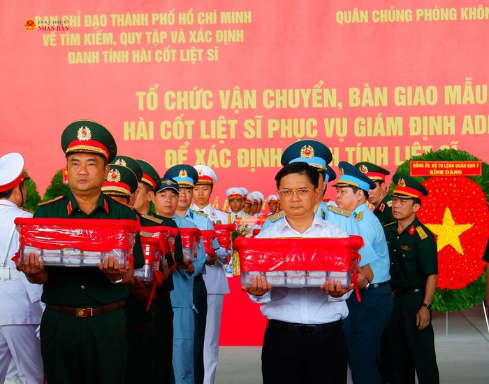 Tư lệnh Quân khu 7, Trung tướng Lê Xuân Thế và Phó chủ tịch UBND TP. Hồ Chí Minh, Trưởng Ban Chỉ đạo 515 thành phố Nguyễn Mạnh Cường đưa thùng chứa mẫu sinh phẩm hài cốt liệt sĩ lên máy bay. Ảnh: Hoa Lê