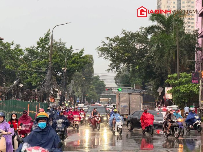 Người dân mặc áo mưa, chật vật di chuyển trong thời điểm tan tầm.