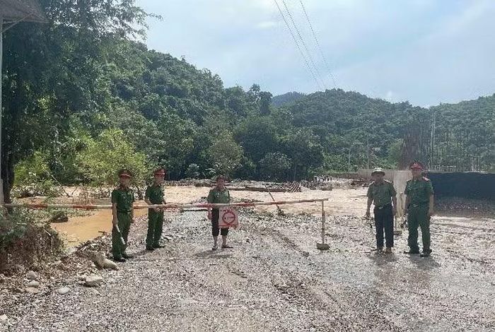 Cầu tràn ngập nước, Công an xã Tam Thái lập barie cảnh báo phương tiện và người dân qua lại.