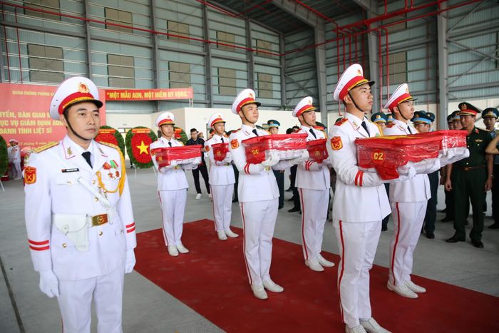  100 thùng mẫu sinh phẩm hài cốt liệt sĩ được phủ Quốc kỳ trang nghiêm. 