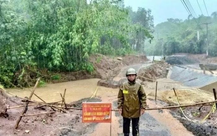 Công an xã A Dơi trực cảnh báo, hướng dẫn người dân không được qua lại khu vực bị sạt lở nguy hiểm.