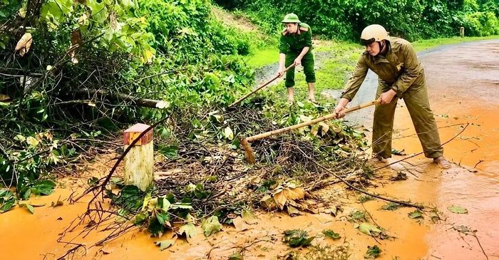 Cán bộ, chiến sĩ Công an xã Hướng Phùng phát quang, thu dọn cây cối, cành nhánh và thực bì tràn xuống đường sau mưa, bảo đảm an toàn cho người và phương tiện lưu thông.