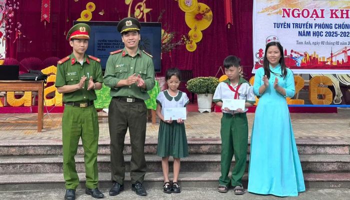 Đoàn viên thanh niên Công an xã Tam Anh trao quà tặng các em học sinh có hoàn cảnh khó khăn học giỏi.