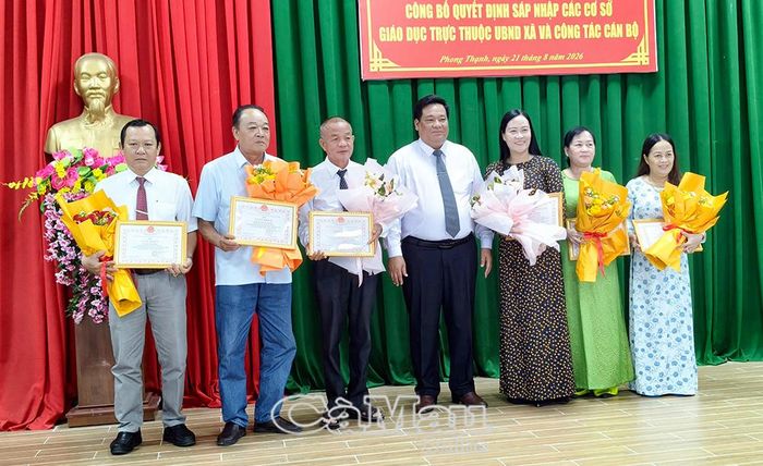 Đồng chí Trần Văn Hùng, Chủ tịch UBND xã Phong Thạnh (giữa), tặng hoa và giấy khen cho nguyên lãnh đạo các trường sau sáp nhập tự nguyện nghỉ hưu trước tuổi.
