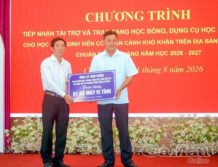 Ông Lê Văn Phúc, Phó Giám đốc Trung tâm Xúc tiến đầu tư và Dịch vụ tài chính công tỉnh Cà Mau (bìa trái), trao bảng tượng trưng tặng 1 bộ máy vi tính cho Hội Khuyến học địa phương.