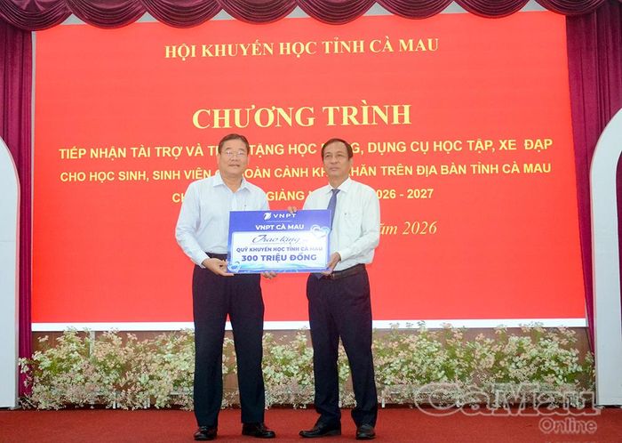 Ông Trần Hồng Quân, Chủ tịch Hội Khuyến học tỉnh Cà Mau (bìa phải), tiếp nhận bảng tượng trưng 300 triệu đồng do VNPT Cà Mau trao tặng Quỹ Khuyến học tỉnh.