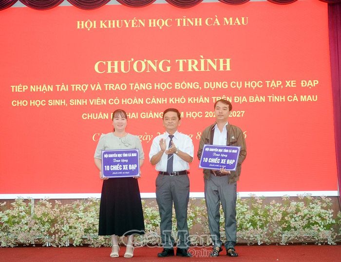 Ông Nguyễn Bá Long, Phó Chủ tịch Thường trực Hội Khuyến học tỉnh Cà Mau, trao bảng tượng trưng tặng 20 xe đạp cho Hội Khuyến học các xã, phường.