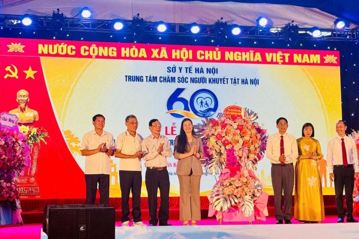 Trưởng ban Văn hóa - Xã hội HĐND thành phố Hà Nội Bạch Liên Hương trao lẵng hoa tặng Trung tâm. Ảnh: Mai Hoa