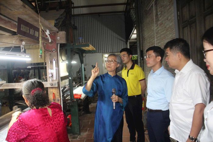 Các đại biểu thăm làng nghề Vạn Phúc, nghe các nghệ nhân giới thiệu về nghề dệt... Ảnh: Kim Huệ