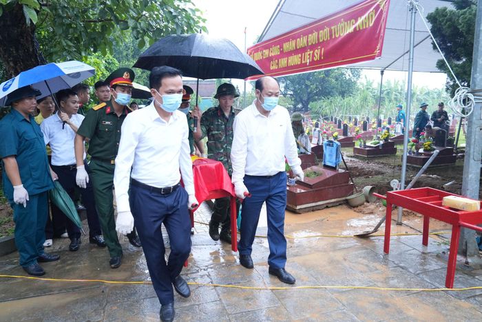 Chủ tịch UBND xã Tây Phương Cấn Văn Hương; Trung tá Nguyễn Tô Duy, Chỉ huy trưởng Ban Chỉ huy quân sự xã Tây Phương và lực lượng làm nhiệm vụ đưa phần mộ chưa xác định được danh tính về khu vực lấy mẫu. Ảnh: Công Phương