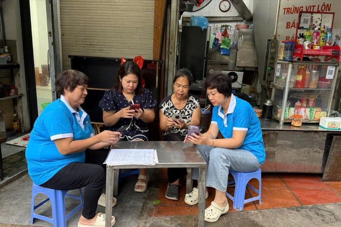 Hội viên Chi hội phụ nữ tổ dân phố số 1 phường Văn Miếu - Quốc Tử Giám trực tiếp hướng dẫn các hộ kinh doanh cài đặt mã QR để thanh toán không dùng tiền mặt. Ánh: An Quyên