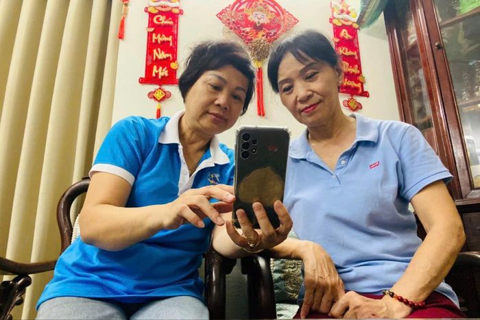 Bà Ngô Thị Lệ Thu, Chi hội trưởng Chi hội phụ nữ tổ dân phố số 1 hướng dẫn người dân cài đặt ứng dụng số. Ảnh: An Quyên