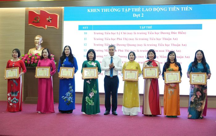 Phó Bí thư Thường trực Đảng ủy xã Thuận An Đào Xuân Trường trao khen thưởng cho các tập thể lao động tiên tiến. Ảnh: Vân Thư