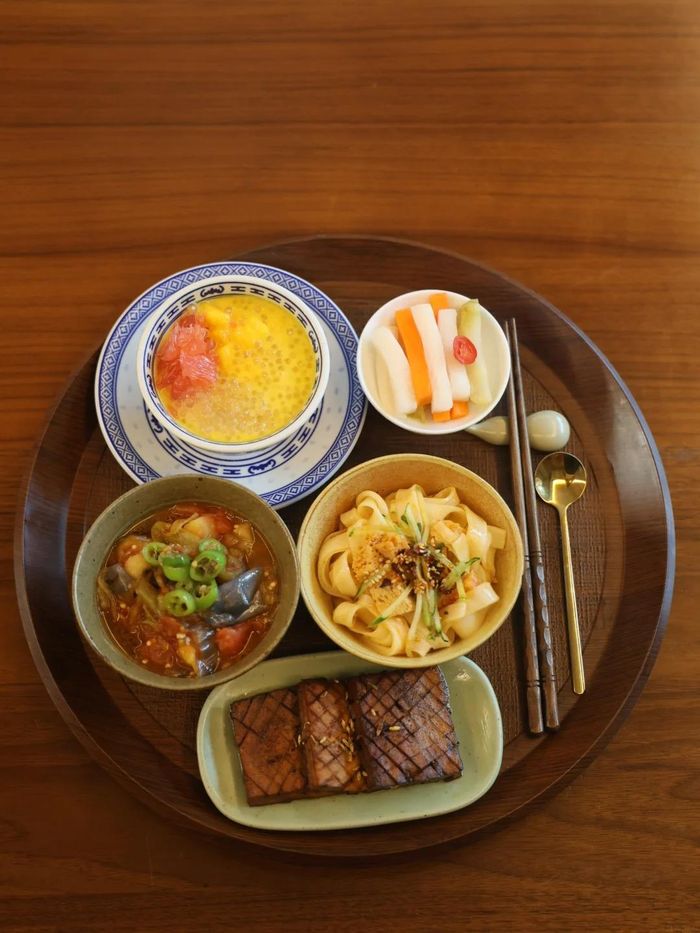  Thực đơn 8: Bánh phở trộn sốt mè cay, đậu phụ khô xào thì là, cà tím trộn cà chua, dưa muối thập cẩm, chè xoài nước cốt dừa. 