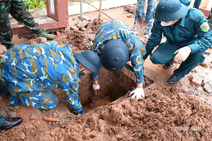 Hố khai quật được mở để tiếp cận phần mộ liệt sĩ. Ảnh: Tuấn Anh