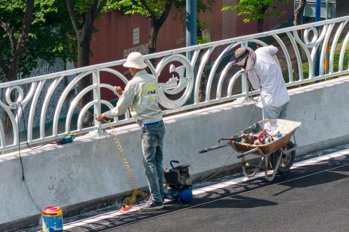 Phía trên cầu đang được đơn vị thi công hoàn thiện các đoạn lan can cuối cùng trong sáng 22/8. Lan can bằng thép cao hơn 1,5 m, có hình logo TP.HCM.