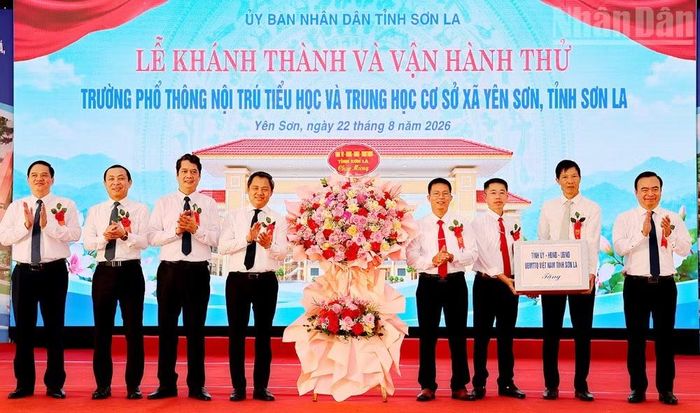 Các đồng chí lãnh đạo tỉnh Sơn La tặng hoa và quà chúc mừng lãnh đạo Trường phổ thông nội trú Tiểu học và Trung học cơ sở tại xã Yên Sơn. (Ảnh: QUỐC TUẤN)