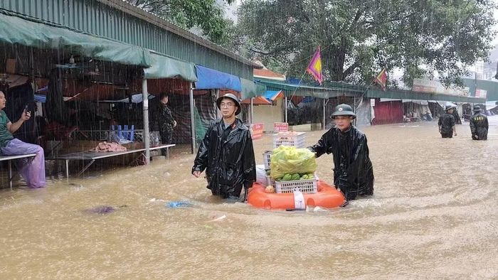 Lực lượng quân sự Lạng Sơn hỗ trợ di chuyển hàng hóa tại khu vực chợ Giếng Vuông, phường Kỳ Lừa. (Ảnh: QSLS)