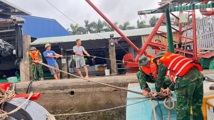 Cán bộ, chiến sĩ Biên phòng hỗ trợ bà con ngư dân chằng, buộc phương tiện để tránh trú bão.